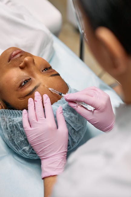 Close-up of a cosmetic professional administering a Botox injection on a patient's forehead in a clinic.